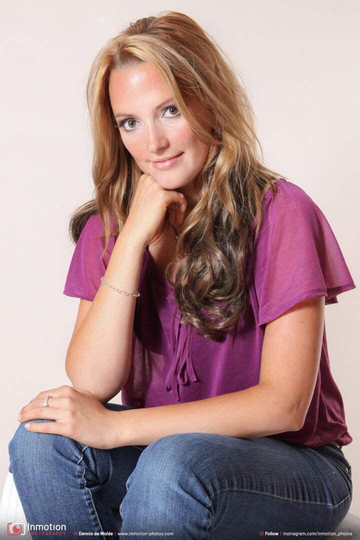 Suzanne Poses Sitting In Jeans And Purple Shirt
